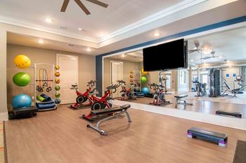 a gym with exercise equipment and a tv on the wall at Century New Holland, Gainesville, GA, 30501